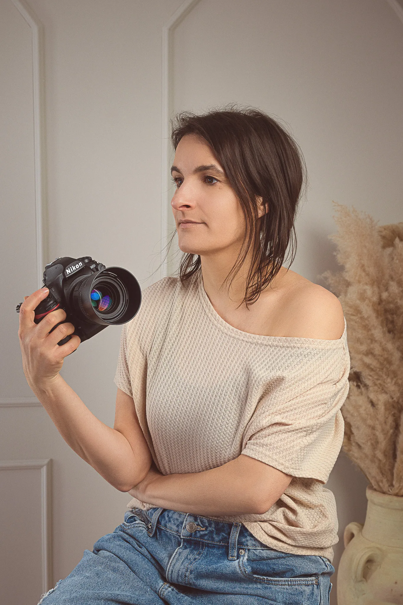 Profesionalna fotografinja Vani s fotoaparatom v rokah v svojem boho studiu.