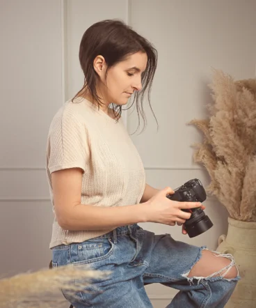 fotografinja-vani-priprava-fotoaparata Fotografinja Vani sedi na stolčku in preverja nastavitve na svojem fotoaparatu.Fotografinja Sežana