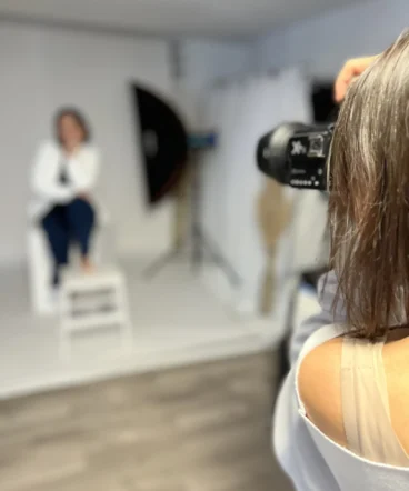 vani-foto-fotografinja-v-akciji-belo-ozadje Umetniški pogled čez ramo fotografinje Vani med fotografiranjem stranke v studiu.